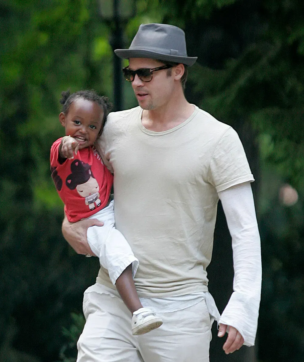 Zahara Jolie Pitt And Brad Pitt, Arm, Shoulder, White, Vision care, Sunglasses, Sleeve, Hat, Eyewear, Gesture, Cap