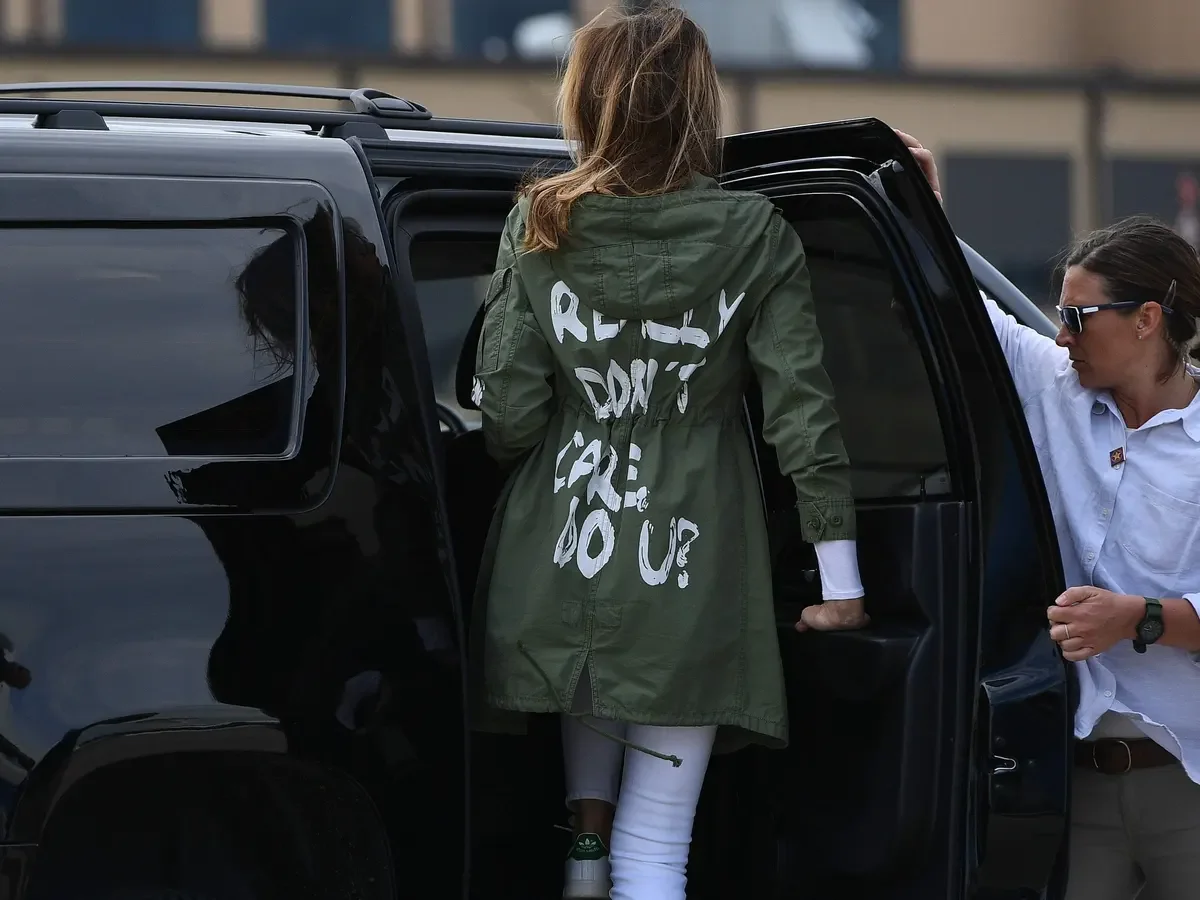 Melania Trump I Don T Care Jacket, Motor vehicle, Automotive design, Automotive lighting, Fashion, Sleeve, Textile, Car, Vehicle, Gesture